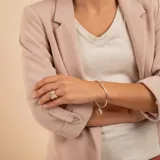 Brazalete tipo esclava de alambre redondo en plata 925, con dije de medalla circular colgante.