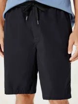 Bermuda de corte recto en color negro, confeccionada en tejido de algodón, con cierre frontal y bolsillos laterales.