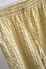 Pantalón de corte recto y holgado, con estampado de cuadros vichy en rojo y blanco. Tiene cintura elástica con cordón ajustable.
