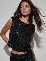 Top de lentejuelas negro sin mangas, corte recto y corto tipo crop top.