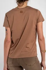 Remera de algodón peinado color marfil, de manga corta y corte al cuerpo, con escote en V ribeteado con hilo dorado.