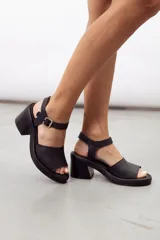 Sandalia de cuero marrón con diseño open-toe, tira ancha en el empeine, correa ajustable con hebilla en el tobillo y tacón ancho de madera.