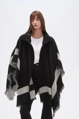 Poncho de tejido grueso, color negro y gris, con diseño de franjas diagonales y cuello alto con cierre. Presenta terminaciones con flecos.