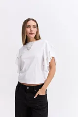 Remera negra de algodón con mangas cortas que presentan volados dobles, aportando volumen y movimiento a la prenda.