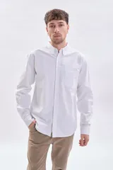 Camisa de manga larga oxford en color blanco, con cuello abotonado y bolsillo frontal en el pecho.