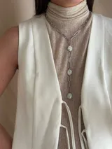 Corbatín con cadena de acero quirúrgico color plateado y perlas de río. Se puede usar ajustado al cuello o más suelto. Se cierra con ganchito para regular el largo.