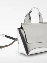 Mini bolso plateado con acabado metalizado efecto espejo, solapa con cierre magnético y asa de mano. Incluye bolsillo interior y asa larga regulable y extraíble.