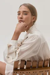 Falda corta de color blanco con diseño de doble volado y delicados bordados en tonos suaves que aportan movimiento y estilo.