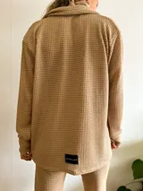 Camisa de tejido tipo waffle color arena, con diseño abierto, mangas largas y corte holgado.