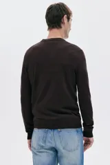 Buzo de punto fino color marrón oscuro, con cuello redondo y remates acanalados en cuello, puños y bajo. Corte estándar.