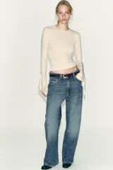 Camiseta de cuello redondo y manga larga, confeccionada en tejido rib con mezcla de lyocell. Presenta un diseño ajustado con terminación de volantes en los puños y bajo recto.