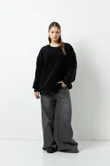 Buzo negro de tela tipo teddy, de manga larga y cuello redondo. Presenta recortes de nylon en mangas y laterales.