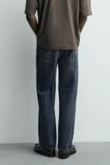Pantalón jeans straight ankle fit de tiro medio, confeccionado en denim de algodón con efecto lavado. Presenta diseño de cinco bolsillos y cierre frontal con cremallera y botón.