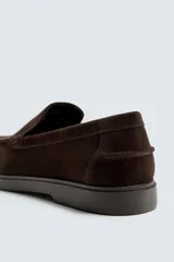 Mocasín casual de hombre con parte superior de piel con acabado serraje, diseño de corte liso con detalle de bordón, horma redonda y suela a tono.