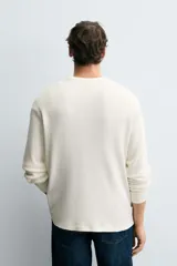 Camiseta de manga larga con cuello redondo, confeccionada en tejido de algodón con textura tipo waffle y acabados en rib.