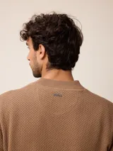Sweater de punto color negro, con cuello alto y cierre frontal parcial tipo medio cierre. Presenta textura en el tejido y logo bordado en el pecho.