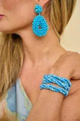 Aros colgantes color turquesa con diseño en forma de lágrima, elaborados con cuentas de abalorios texturizadas.