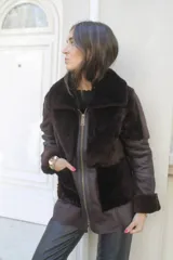 Gamulán reversible de cuero genuino color marrón oscuro, con interior de piel sintética al tono, cierre frontal y cuello amplio.