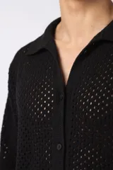 Camisa de manga corta tejida en algodón con diseño calado, cuello tipo bowling y cierre frontal con botones al tono.