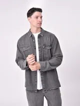 Sobrecamisa de jean celeste con dos bolsillos frontales con solapa y cierre con botones.