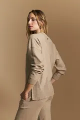 Polera de tejido de punto color marrón, con cuello alto y diseño de líneas verticales en el frente que aportan estructura. Presenta un calce relajado y mangas largas con puños ajustados.