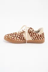 Zapatilla de cuero con textura de pelo y estampado animal print de puntos, con detalles en cuero liso color crema en los laterales y talón, y suela de goma color caramelo.