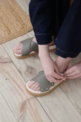 Sandalias bajas color verde oliva, con dos tiras anchas cruzadas sobre el empeine y tira trasera con hebilla.