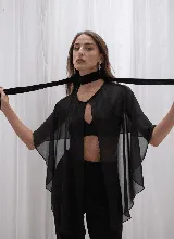 Capa de microtul color verde oscuro con diseño versátil, cierre frontal con botón y corte amplio con caída fluida.