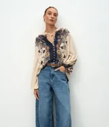 Pantalón barrel de jeans de tiro medio, con piernas amplias y afuniladas en el ruedo. Posee bolsillos funcionales, trabillas y cierre delantero con botón y cremallera.
