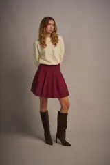 Minifalda de hilo color borgoña, de tiro alto y diseño plisado.