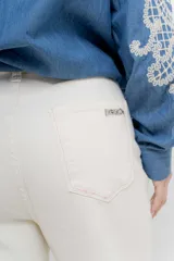 Jean de tiro alto, recto a la pierna, con cinco bolsillos, cierre frontal con cremallera y un botón. Pespunte en rosa.