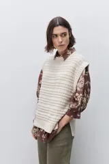 Chaleco tejido azul de calce relajado, silueta recta, cuello redondo, hombros caídos y diseño de punto con textura calada.