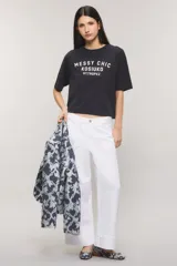 Remera Kosiuko de algodón color blanco, de corte regular y mangas cortas hasta el codo. Cuenta con un diseño estampado en el frente con la leyenda "Messy Chic Kosiuko St. Tropez".