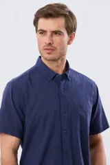 Camisa de manga corta confeccionada en mezcla de lino y algodón, color beige, con cuello camisero abotonado, bolsillo frontal en el pecho y cierre de botones.