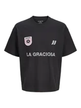 Remera negra de manga corta y cuello redondo, de corte holgado. Cuenta con estampado frontal de estilo deportivo que incluye la inscripción "LA GRACIOSA", un parche circular con diseño de sol y el logo de la marca.