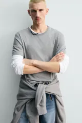 Camiseta de algodón gris jaspeado, de corte regular, con cuello redondo y manga corta.