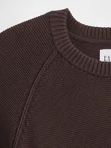 Buzo de punto para hombre, de color azul marino, con cuello redondo y mangas tipo raglán. Presenta puños y ruedo acanalados.