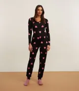 Conjunto de pijama largo confeccionado en rib, compuesto por una blusa de manga larga con botones y un pantalón con cintura elástica. Estampado de corazones.