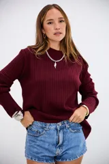 Sweater de tejido de punto acanalado en color bordó, con cuello redondo y mangas largas. Presenta un corte holgado y cómodo.