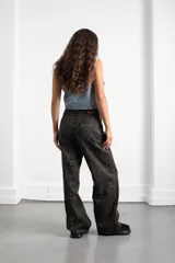 Pantalón de jean con estampado animal print en tonos oscuros, de corte recto y tiro medio. Cuenta con bolsillos traseros y etiqueta de cuero sintético con el logo de la marca en la cintura.