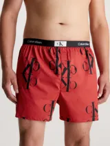Boxer de algodón con estampado repetido del logo 'CK' en negro sobre fondo rojo. Cintura elástica negra con el logo 'Calvin Klein' en blanco.