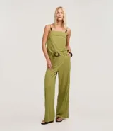 Pantalón pantalona color verde oliva, confeccionado en tejido orly con viscosa certificada. Presenta trabillas largas en la cintura, cierre tradicional, bolsillos y frisos delanteros. Incluye cinturón largo de tejido con hebilla irregular.