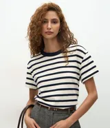 Blusa de corte boxy confeccionada en algodón, con diseño de rayas horizontales, cuello redondo de punto en contraste y mangas cortas.