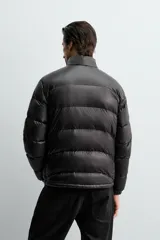 Cazadora acolchada de corte regular, confeccionada en tejido técnico repelente al agua. Presenta cuello subido, cierre frontal de cremallera, mangas largas con puños elásticos y bolsillos laterales con cremallera oculta.