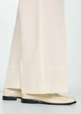 Pantalon de vestir de corte recto y tiro alto, color beige, con detalle de pinzas frontales, bolsillos laterales y cierre oculto.