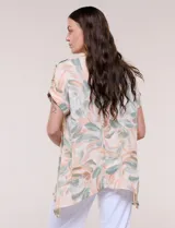 Blusa de silueta holgada confeccionada en crepé liviano, con estampado abstracto en tonos rosados, verdes y blancos. Presenta escote redondo amplio, hombros caídos con hilera de botones decorativos, mangas cortas con dobladillo y ruedo asimétrico en picos.