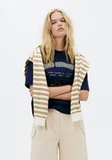 Remera color crema de corte amplio con estampa de un pescado y texto en azul marino.