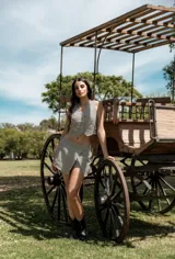 Conjunto de dos piezas compuesto por un chaleco corto con botones frontales y una falda corta tipo short con diseño cruzado, ambos con estampado de rayas verticales.