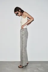 Jeans de tiro alto, pernera recta y larga, estilo clásico con cinco bolsillos, cierre frontal con cremallera y botón metálico.