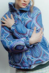 Campera puffer azul con estampado de motivos geométricos y figuras como estrellas de mar y sirenas.